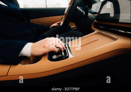 Die Hand eines Mannes an einem Automatikgetriebe. Hochwertige Fotos Stockfoto