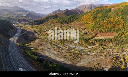 Herbstlicher Blick auf das Dorf Zall-Xhuxhë und die Autobahn A1, die sich durch die farbenfrohen Berge des Bezirks Mirditë schlängelt. Stockfoto