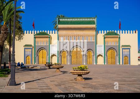 Kunstvoller Palast mit goldenen Türen und detailliertem Mosaik vor einem klaren blauen Himmel. Fès, Fès-Meknes, Nordmarokko Stockfoto