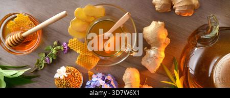 Hintergrund mit Ingwer und Honigaufguss auf einem Holztisch mit Produkten wie Ingwerwurzeln, Gläsern mit Honig, Pollen und Wabendekor Stockfoto