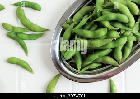 Top View Green Edamame Beans, Raw Sojabohnen bereit zum Kochen. Weißer Hintergrund. Stockfoto