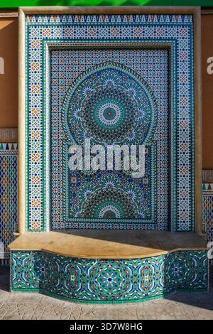 Kunstvoller Mosaikbrunnen mit komplexen geometrischen Mustern und lebhaften Farben in traditionellem Stil. Marrakesch, Marokko Stockfoto