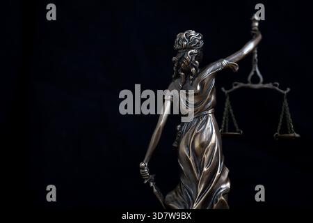 Lady Justice Metallstatue auf schwarzem Hintergrund. Recht und Gerechtigkeit Stockfoto