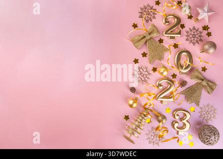 Hintergrund für die Neujahrsfeier 2023 Grußkarte Gold-Zahlen 2023 mit goldener Partydekoration, Sternchen Konfetti auf pinkfarbenem Hintergrund. Flach liegend, Merry Stockfoto