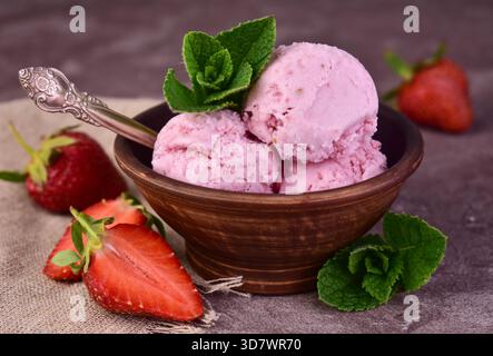 Erdbeer-Eisschaufeln in einer Tonschale. Nahaufnahme. Stockfoto