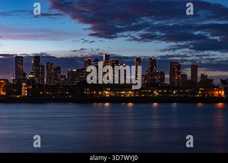 Ein Bild der modernen Apartments und Büros auf der Isle of Dogs und Canary Wharf, die bei Sonnenuntergang über die Themse gesehen werden. Stockfoto