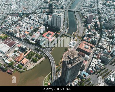 Stadt mit einem Fluss, der durch sie fließt. Es gibt viele Gebäude und eine Brücke. Die Gebäude sind hoch und die Brücke ist lang Stockfoto