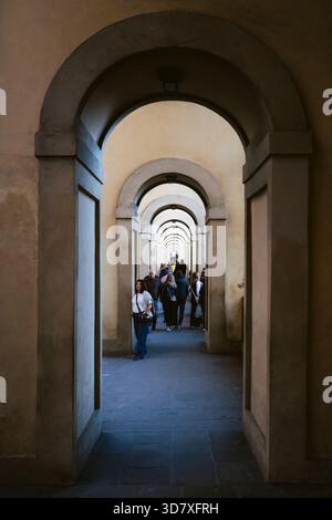 Touristen spazieren durch die Arkaden des Vasari-Korridors auf der Ponte Vecchio, Florenz, Toskana, Italien Stockfoto
