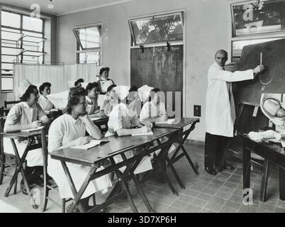Ein Arzt unterweist Hebammen in den 1950er Jahren Stockfoto
