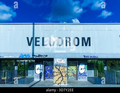Nahaufnahme des Velodrom-Eingangs in Berlin mit Schwerpunkt auf der großen Fassadenbeschriftung und umgebenden Graffiti. Stockfoto