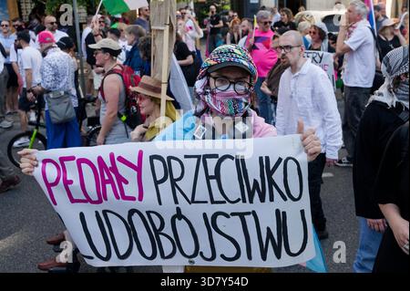 Der Protestteilnehmer hält ein handgeschriebenes Schild, während er während des Warschauer Pride (Parada Równości) unter einer großen Menschenmenge steht. Stockfoto