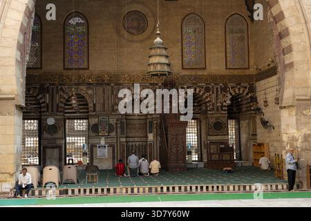 Männer beten vor dem Mihrab im erhöhten Hauptiwan der Al-Ashrafi-Moschee-Madrasa im historischen Kairo, Ägypten. Stockfoto