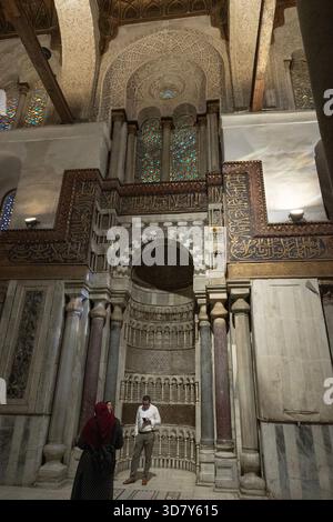 Drei Personen im reich geschmückten Mihrab in der Moschee des Qalawun-Komplexes aus dem XIII. Jahrhundert im historischen Kairo, Ägypten. Stockfoto