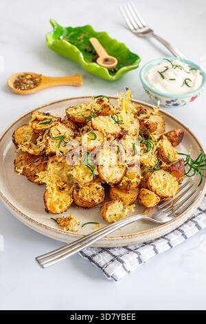 Vertikaler Hochwinkel aus knusprigen Röstkartoffeln mit goldenem Parmesankäse, garniert mit frischen Rosmarinblättern Stockfoto