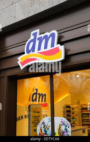Bamberg, Deutschland 27. November 2025: Im Bild: Eingangsbereich einer dm Drogeriekette in der Bamberger Innenstadt. Das markenspezifische Logo im Store ist über dem Eingang zu sehen; innen sind Regale und Produktauslagen zu sehen. Neutrale Architektur Stockfoto