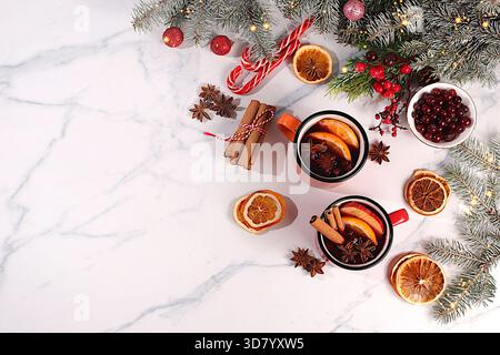 Warmes Wintergetränk in der kalten Jahreszeit, ein festlicher Weihnachtsgrog, ein starker alkoholischer oder alkoholfreier Cocktail in eisernen Tassen, Glühwein mit Gewürzen, Stockfoto