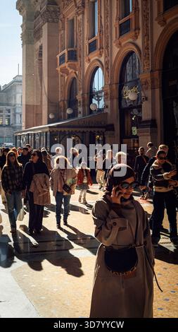 „Menschenmenge, die in der historischen Galleria Vittorio Emanuele II in Mailand, Italien, spaziert, während Sonnenlicht durch die Arkade strömt.“ Stockfoto
