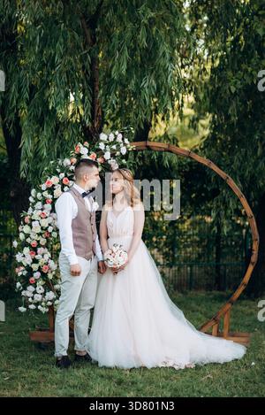 Hochzeitszeremonie eines verliebten jungen Paares auf einer grünen Wiese im Wald Stockfoto
