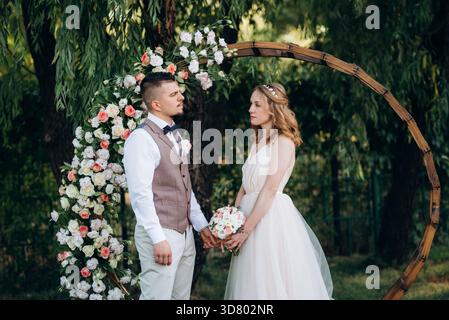 Hochzeitszeremonie eines verliebten jungen Paares auf einer grünen Wiese im Wald Stockfoto