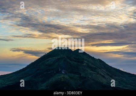 Malerischer Sonnenaufgang am Vulkan Batur und Agung, Kintamani, Insel Bali, Indonesien. Blick auf den Vulkan bei Sonnenaufgang von der Spitze des Berges Batur, Naturlandschaft. Clo Stockfoto