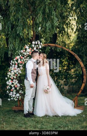 Hochzeitszeremonie eines verliebten jungen Paares auf einer grünen Wiese im Wald Stockfoto