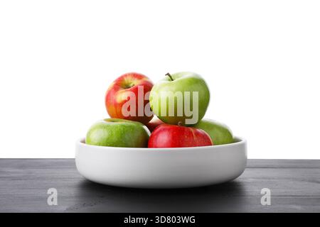 Rote und grüne reife Äpfel in der Schüssel auf Holztisch vor weißem Hintergrund Stockfoto