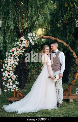 Hochzeitszeremonie eines verliebten jungen Paares auf einer grünen Wiese im Wald Stockfoto
