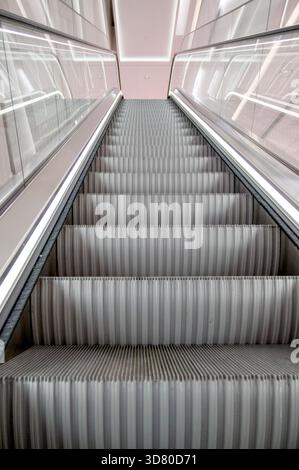 Blick auf eine moderne beleuchtete Rolltreppe in einem Gebäude. Stockfoto