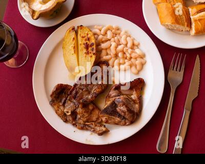 Gebratenes Lamm mit Bohnen und halber Kartoffel. Stockfoto
