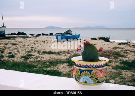 Kleiner Kakteen in einer Keramikvase an einer sizilianischen Küste mit Blick auf das Mittelmeer Stockfoto