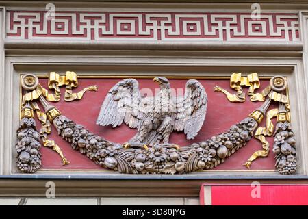 Kunstvoller architektonischer Fries mit Adlermotiv und goldenen Akzenten im klassischen Gebäude. 30. August 2025. Breslau, Polen. Stockfoto