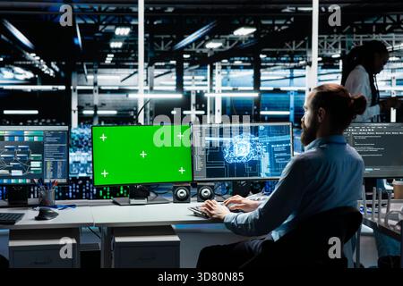 Entwickler im Rechenzentrum verwenden PCs mit isoliertem Bildschirm, optimieren die Ausrüstung für KI-Aufgaben und erhöhen die Arbeitslast. IT-Mitarbeiter im Serverraum automatisieren Systemdiagnosen mithilfe von Deep Learning auf Chroma Key-Computern Stockfoto