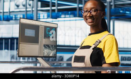 Porträt eines glücklichen Ingenieurs in der intelligenten Photovoltaik-Fabrik, der Daten analysiert und Systemmetriken überprüft. Fröhliche Frau in Industrie 4,0 Solarpaneele Anlage, die erneuerbare Energie produziert, Kamera A Stockfoto