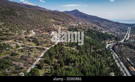 Drohnenblick auf gewundene Bergstraßen mit Blick auf den Lake Ohrid in der Nähe der Küste in Nordmazedonien. Stockfoto