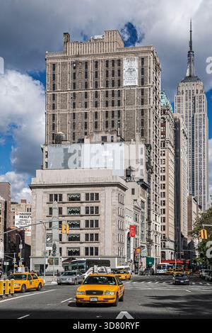 Midtown Manhattan bietet einen atemberaubenden Blick auf das Empire State Building vom Madison Square. Gelbe Taxis und Stadtleben füllen die belebten Straßen darunter. Stockfoto
