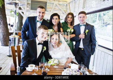 Glückliche Freunde des Brautpaares und Brautführer mit Brautjungfern im café Stockfoto
