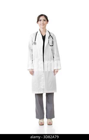 Freundliche asiatische Ärztin. Hochformat in voller Länge. Isoliert auf weißem Hintergrund Stockfoto