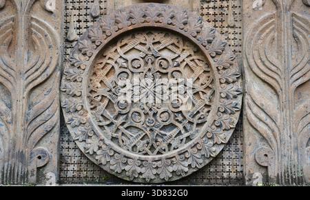 Kunstvoll geschnitztes Medaillon aus armenischem Kirchenstein mit traditionellen ineinander verstrichenen Motiven und Blumenornamenten Stockfoto