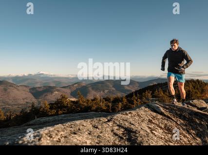 Der Mann läuft entlang des Felskammes in den White Mountains, New Hampshire Stockfoto