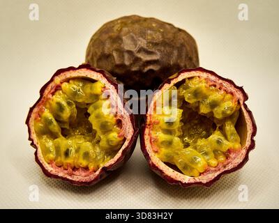 Zusammensetzung der Tropical Passion Frucht: Ganze Frucht und zwei geschnittene Hälften Stockfoto