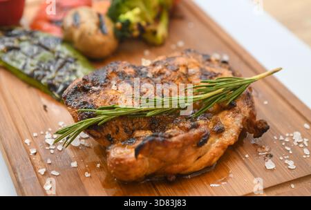 Gegrilltes Hähnchenschenkel mit Rosmarin und geröstetem Gemüse Stockfoto
