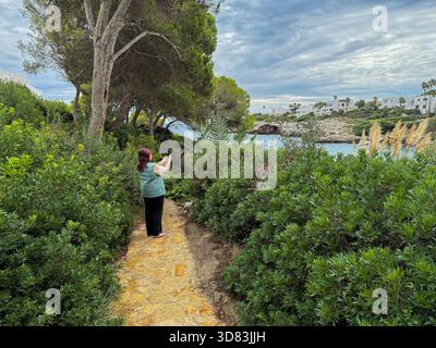 Frau, die Fotos vom Meer auf einem Smartphone auf Mallorca macht Stockfoto