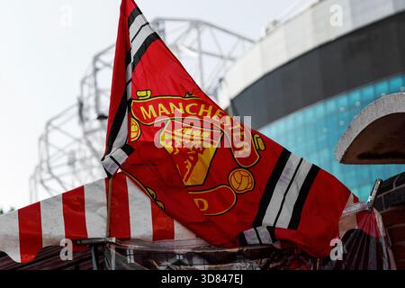 Manchester, England - 17.08.2025: Rote Manchester United Flagge mit Vereinswappen weht in der Nähe des Old Trafford Stadions. Stockfoto