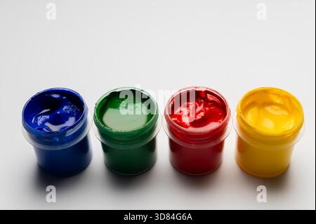 Ein Gemälde- und Kunstset für Kinder. Eine leere weiße Leinwand mit Farbkannen im Hintergrund. Draufsicht und Seitenansicht. Offene Gouachefarben für kreative Anwendungen. Stockfoto