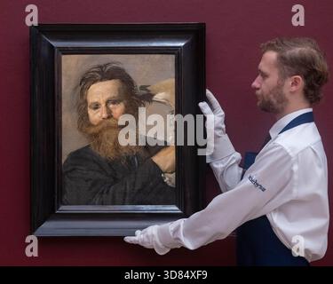 London, England, Großbritannien. November 2025. Ein Kunstschaffender hält Frans Hals’ Portrait of Verdonck Brandishing a Jawbone, geschätzt auf 800.000-1.200.000 GBP, während einer Vorschau in Sothebys in London am 28. November 2025. Das Gemälde wird am 3. Dezember im Verkauf von Gemälden der Alten Meister und des 19. Jahrhunderts angeboten. (Kreditbild: © Thomas Krych/ZUMA Press Wire) NUR REDAKTIONELLE VERWENDUNG! Nicht für kommerzielle ZWECKE! Stockfoto