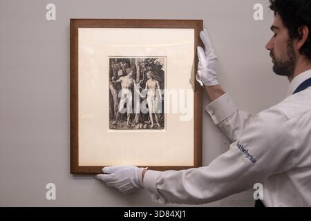 London, England, Großbritannien. November 2025. Ein Sothebys-Kunsthändler hält Albrecht Durers Adam and Eve, geschätzt auf 250.000-450.000 GBP, während einer Vorschau in Sothebys in London am 28. November 2025. Das Werk wird am 3. Dezember im Verkauf von Gemälden der Alten Meister und des 19. Jahrhunderts angeboten und ist derzeit neben außergewöhnlichen Werken von Rubens, Brueghel dem Jüngeren, Frans Hals, Rembrandt und anderen im Rahmen der öffentlichen Ausstellungen der Alten Meister-Woche zu sehen. (Kreditbild: © Thomas Krych/ZUMA Press Wire) NUR REDAKTIONELLE VERWENDUNG! Nicht für kommerzielle ZWECKE! Stockfoto