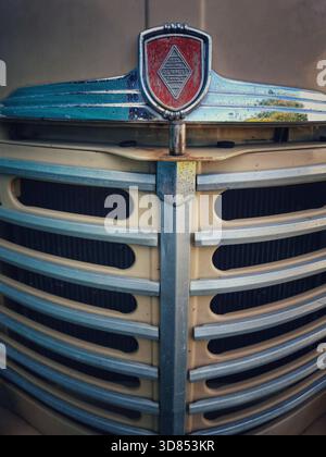 Hier sehen Sie den Grill und die Motorhaube eines älteren Renault-Fahrzeugs. Die Vorderseite trägt das Renault Emblem und weist Rost und Verschleiß am Fahrzeug auf Stockfoto