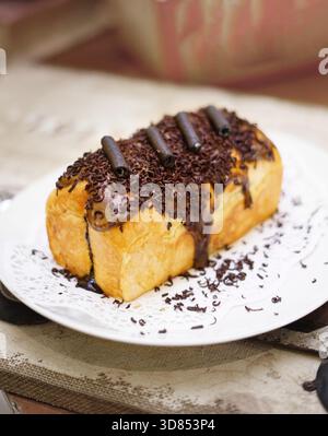 Frisch gegrilltes, leckeres Sandwich mit Belag und Füllung auf weißem Teller, frisch gebacken im Restaurant Stockfoto
