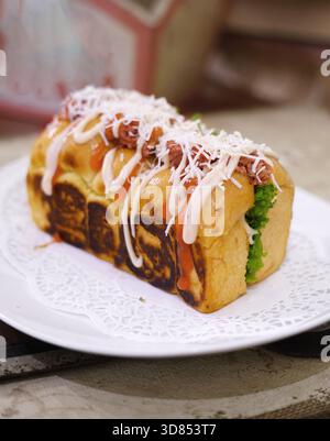 Frisch gegrilltes, leckeres Sandwich mit Belag und Füllung auf weißem Teller, frisch gebacken im Restaurant Stockfoto