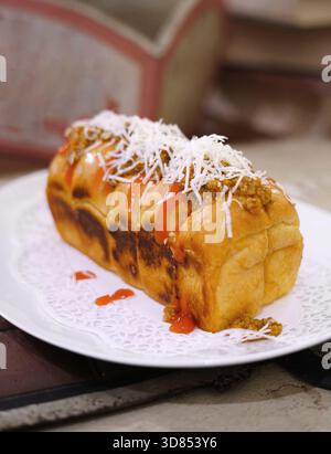 Frisch gegrilltes, leckeres Sandwich mit Belag und Füllung auf weißem Teller, frisch gebacken im Restaurant Stockfoto